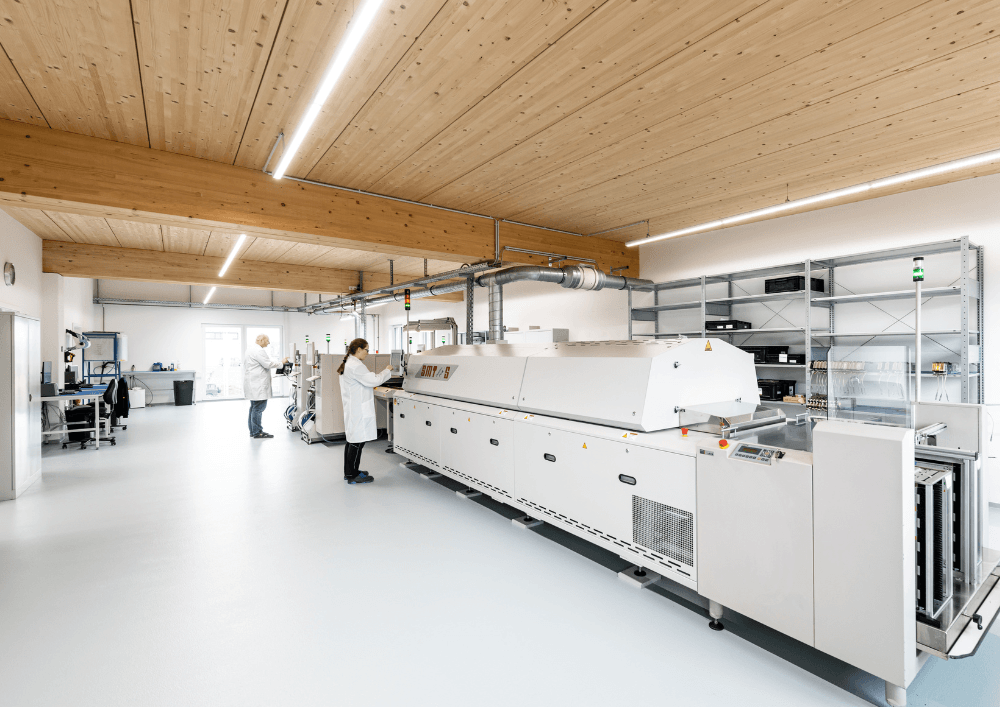 led-beleuchtung-industrie-fertigungshalle-ledoptix Moderne LED-Lichtband-Beleuchtung in einer hellen Fertigungshalle für Industrie und Produktion