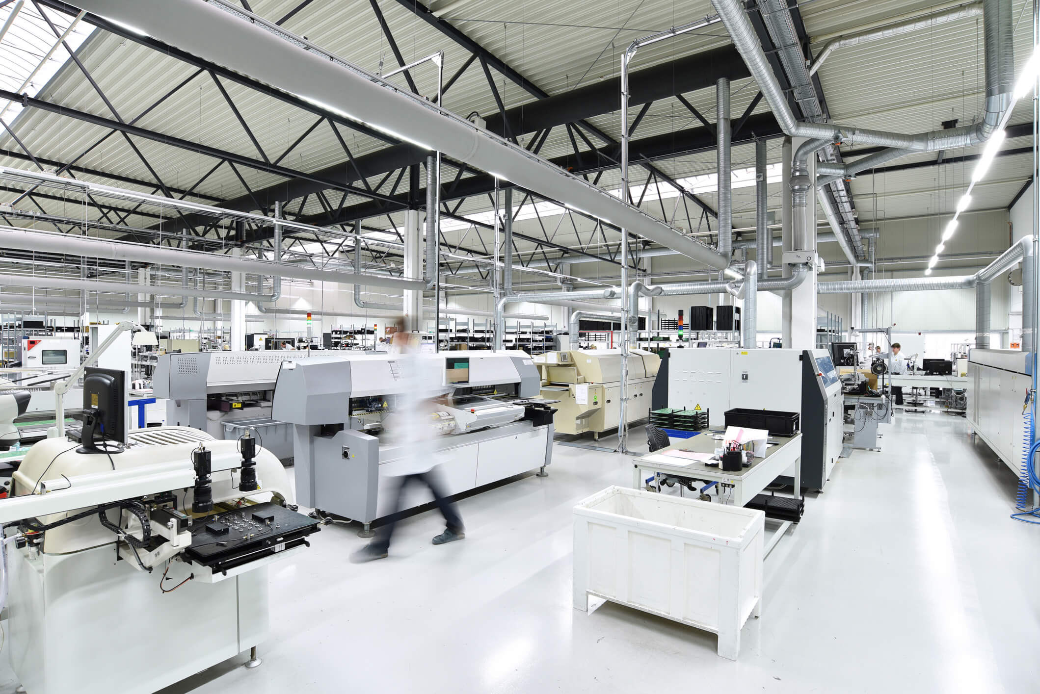 led-hallenbeleuchtung-produktionshalle-lichtband-ledoptix.jpg Großflächige, helle LED-Hallenbeleuchtung mit modularem Lichtbandsystem in einer modernen Industrie-Produktionshalle